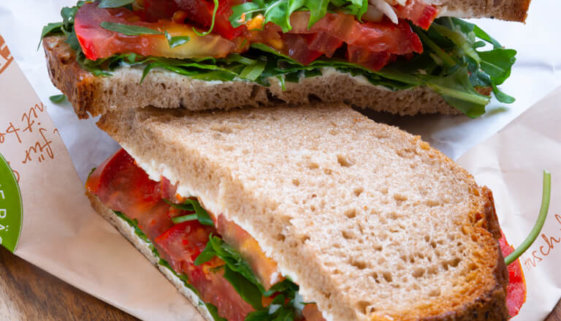 3 Brote mit Frischkäse, Rucola und Tomaten belegt und zusammengeklappt